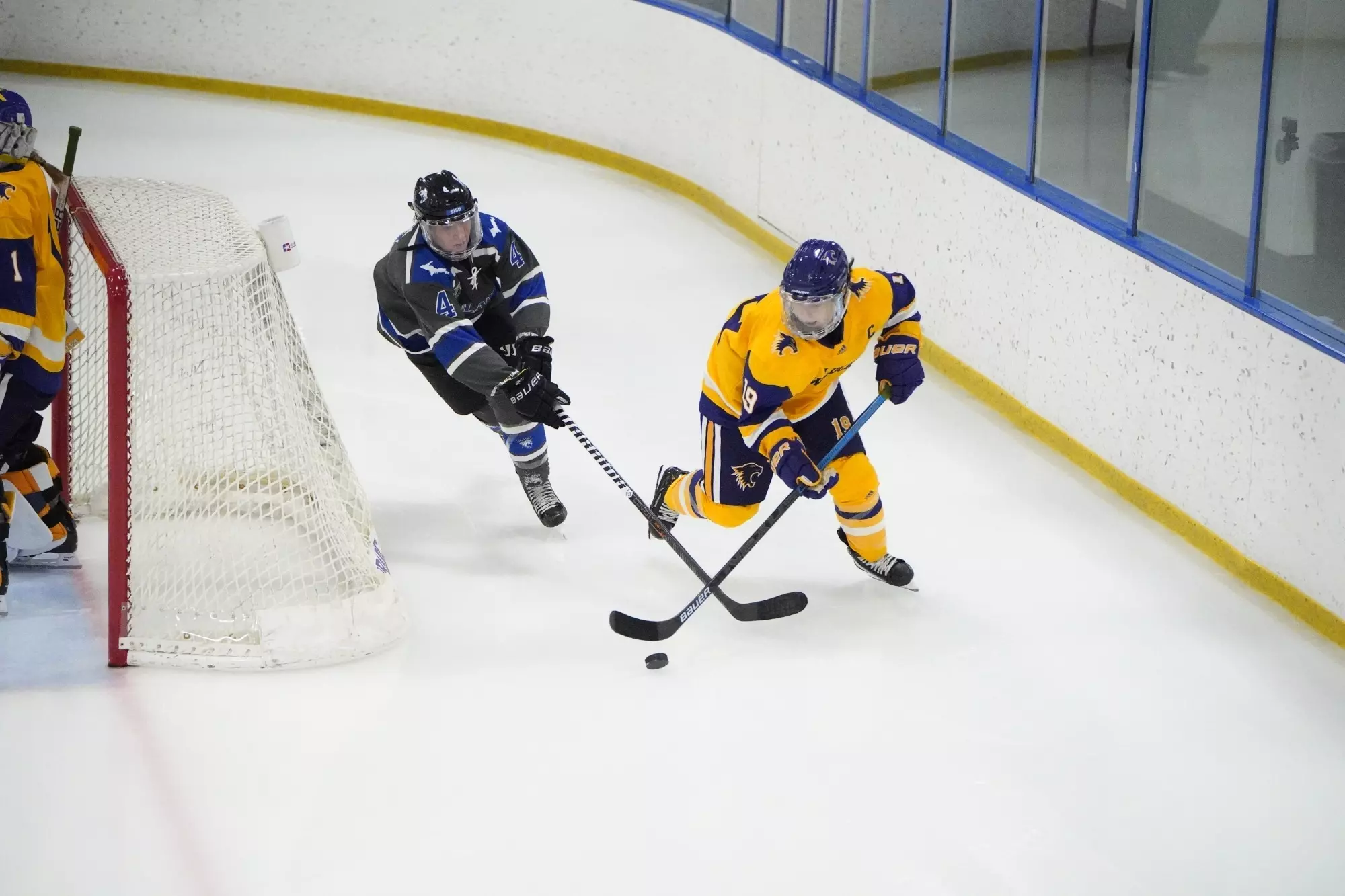 Kaitlyn Blair carrying the puck around the net